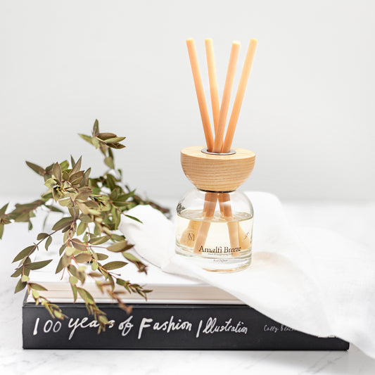 Close up of Amalfi Coast reed diffuser in elegant glass bottle with fibre reeds UK. Amalfi Breeze reed diffuser 100ml with lemon, bergamot and amber notes, long lasting home scent UK