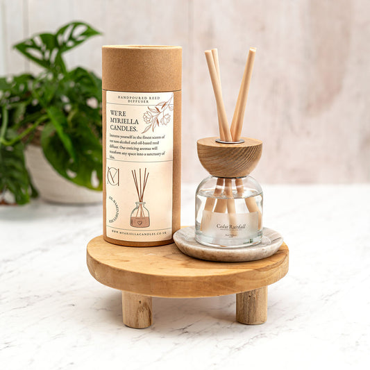 A luxury glass reed diffuser bottle filled with Cedar Rainfall fragrance oil, featuring natural reeds and a minimalist label, handcrafted in Dundee, Scotland.