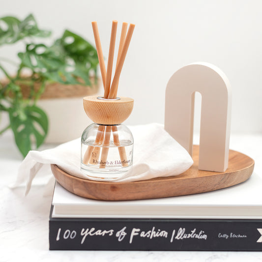 Close up of Rhubarb and Elderflower reed diffuser in elegant glass bottle with fibre reeds UK